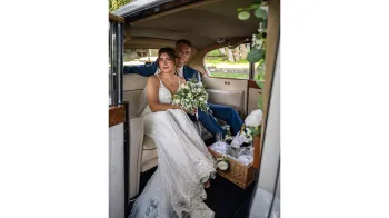 Inside rear photo taken from outside the vehicle with door open showing the large legroom with 2 passengers seating in the vehicle