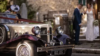 Bride walking down the church's steps towards a Beauford Wedding Car