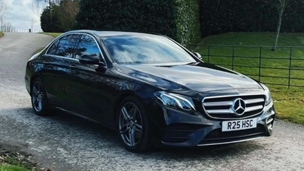 Black Mercedes on a gravel path leading up to the wedidng venue