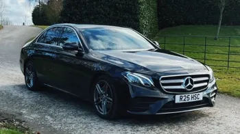 Black Mercedes on a gravel path leading up to the wedidng venue
