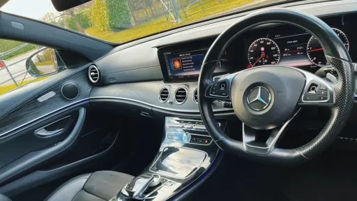 inside Front view of Dashboard and black leather passenger seat in Mercedes E-class