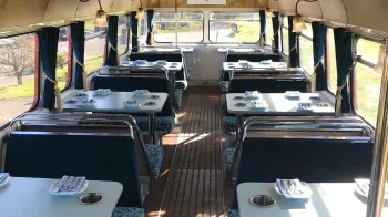 interior view of routemaster bus upper deck with seats and tables