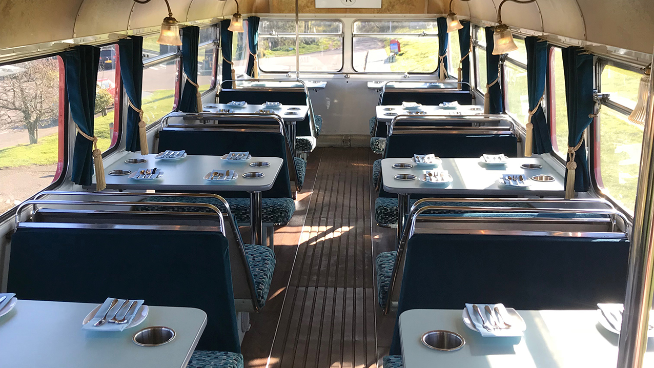 interior view of routemaster bus upper deck with seats and tables