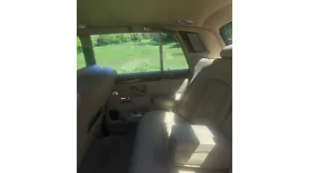 rear passenger seating area in a Classic Rolls-RoyceSilver Shadown with Cream leather interior and matching door cards, wooden picnic table and vanity mirror