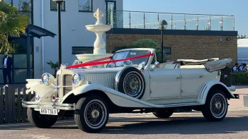 Ivory Convertible Beauford decorated with traditional wedding ribbons accross its bonnet.