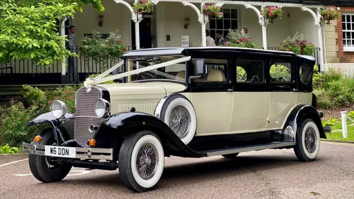 7-seater vintage BRamwith Convertible with White Wall Tires and decorated with white wedding ribbons accross bonnet.