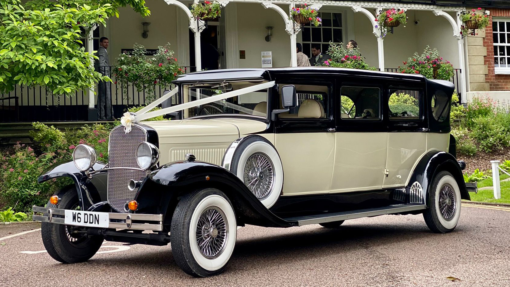 7-seater vintage BRamwith Convertible with White Wall Tires and decorated with white wedding ribbons accross bonnet.