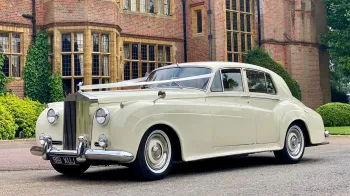Left side view of Classic Rolls=-Royce in front of wedidng venue