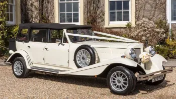 Side view of Convertible Beauford with White Ribbons accross bonnet and closed up Black Soft-Top Roof