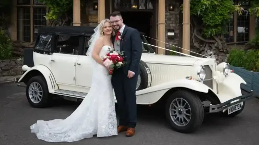 Bride and Groom in front of a Beauford decorated with traditional white ribbons