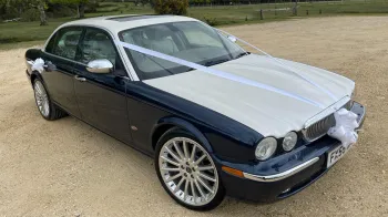 Modern Daimler Super V8 in blue with White bonnet and roof decorated with white ribbons and large bow.