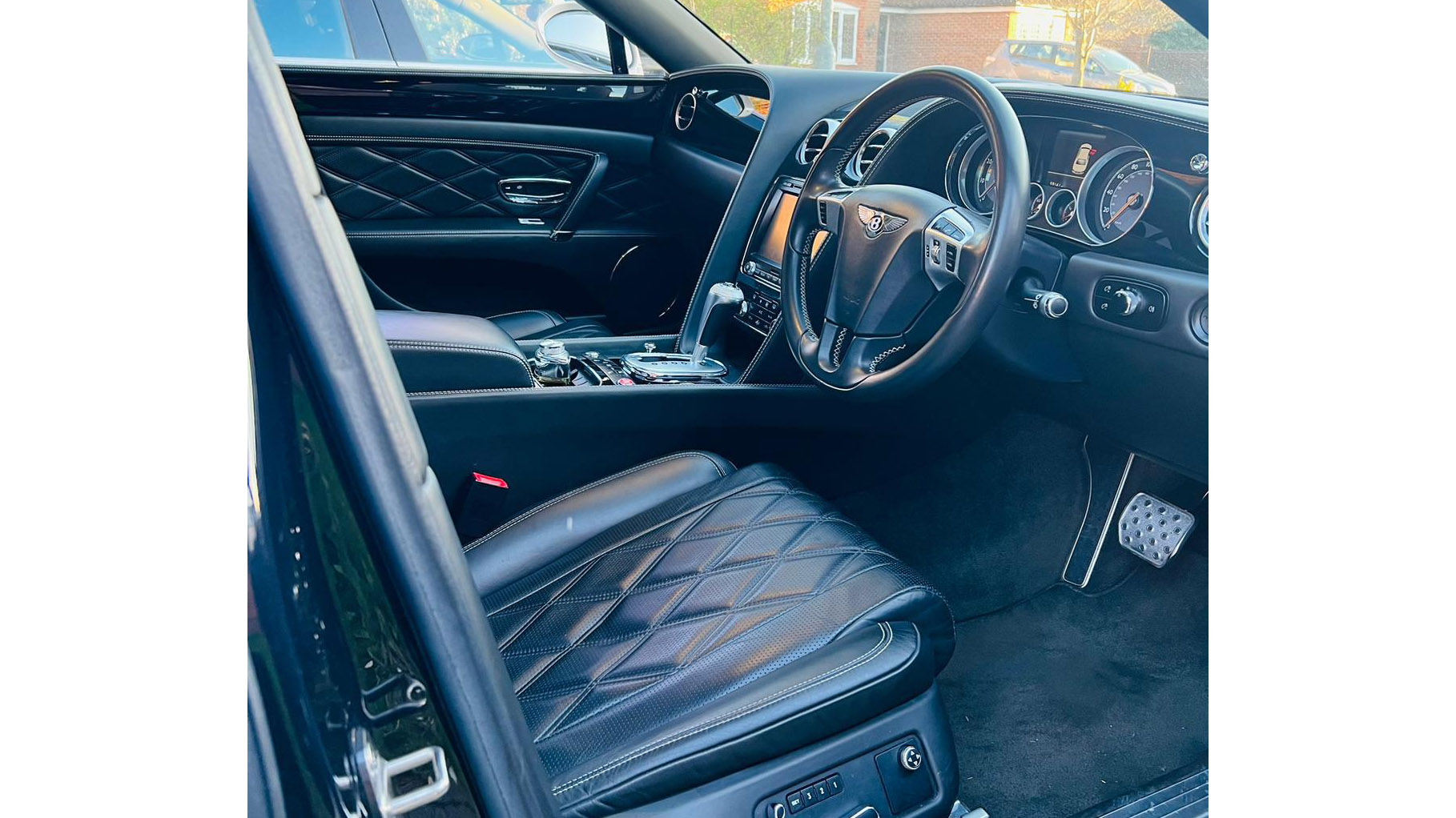 Front interior view of Bentley showing Black Leather interior, Front Dashboard and steering wheels