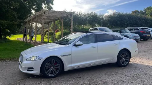 Left view of White Jaguar XJ with Large Chrome Alloy Wheels