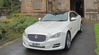 Front View of White Jaguar XJ in front of Wedding Church