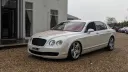 Left Side View of White Bentley Flying spare decorated with a thin Red Ribbon accross its bonnet.