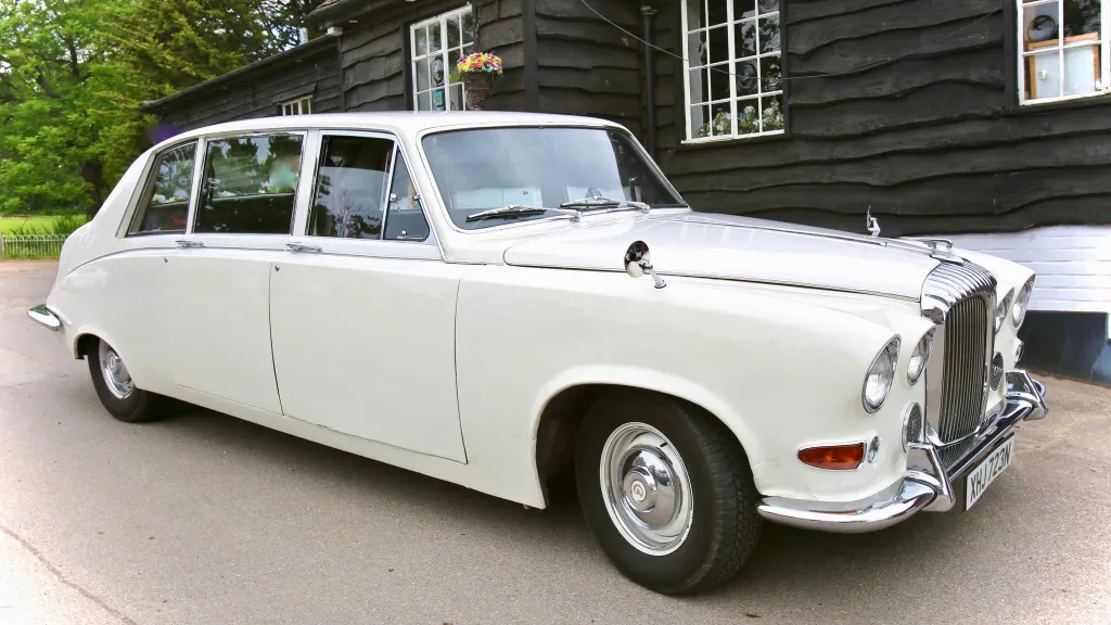 Front Side view of daimler Limousine decorated with ivory wedding ribbons across its front bonnet
