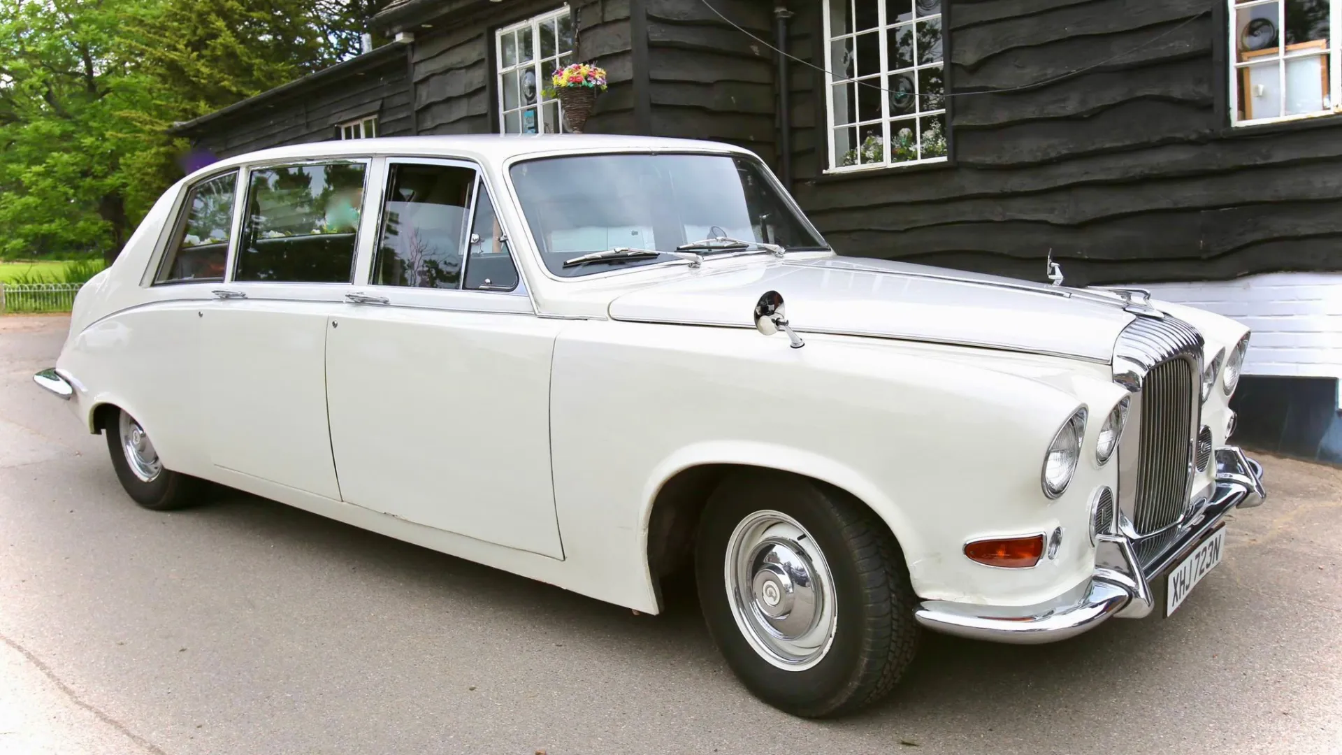 Front Side view of daimler Limousine decorated with ivory wedding ribbons across its front bonnet