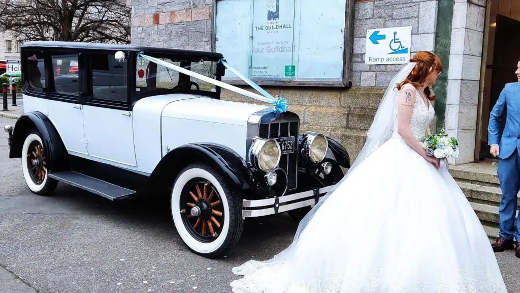 Bride walking in front of the Vintage Franklin holding a bouquet of flower
