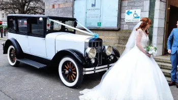 Bride walking in front of the Vintage Franklin holding a bouquet of flower
