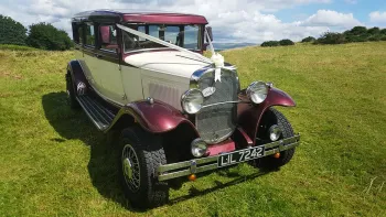 Vintage 7-seater Bramwith Limousine in Ivory and Burgundy decorated with white ribbons