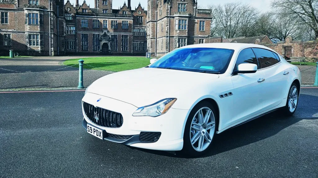 White Maserati in fron of a wedding venue in Birmingham. Venue is a castle style wedding reception