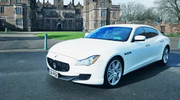 White Maserati in fron of a wedding venue in Birmingham. Venue is a castle style wedding reception