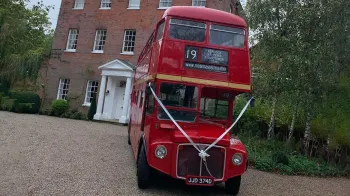 Full front view of Routemaster bsu decorated with white ribbons