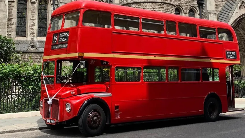 Left Side of Routemaster bus decorated with white ribbons in front of a church