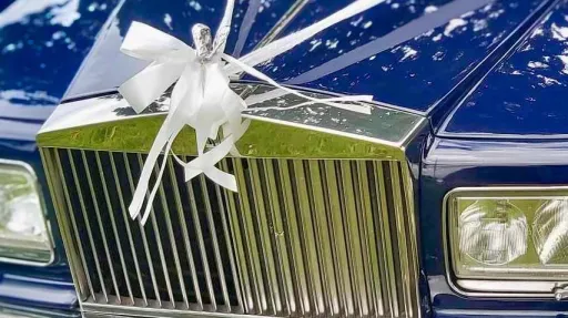 White ribbon on a blue rolls-royce silver spur