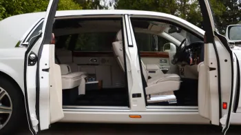 sode view of white phantom with doors open showing cream leather interior.