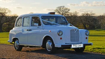 Side view of white classic taxi cab with Orange taxi sign at the top