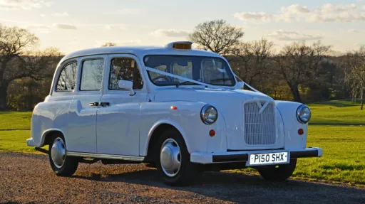 Side view of white classic taxi cab with Orange taxi sign at the top