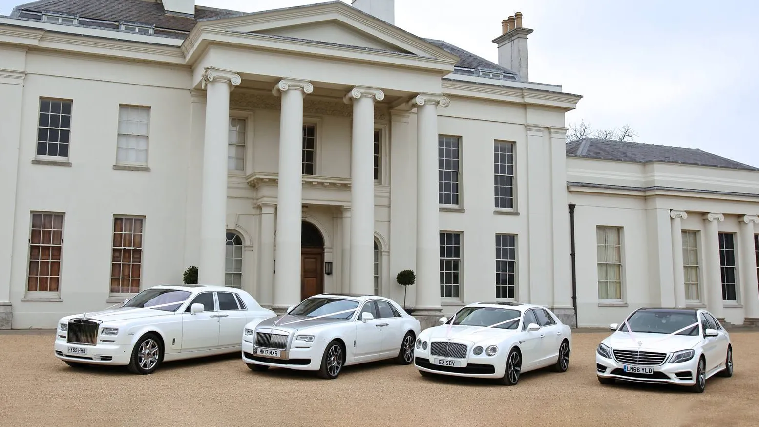 A selection of white Luxurious and modern vehicles all decorated with matching white ribbons on wedding duties in Biggleswade. Frot Left to right: Rolls-Royce Phantom, Rolls-Royce