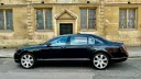 Left side view of Black Bentley parked in the street of Northampton