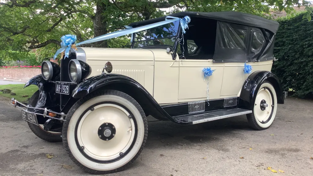 Left view of Vintage Chevrolet in ivory with plain ivory wheels decorated with baby blue ribbons and bow
