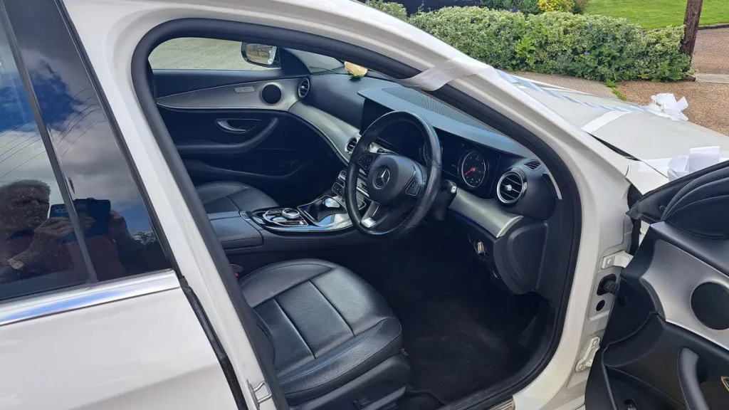 Front driver door open showing black leather