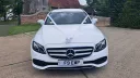 Front view of Mercedes in white decorated with white ribbons in front of a church