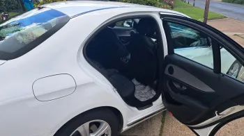 right side rear passenger seating with door open showing black leather seats inside the white mercedes