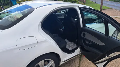 right side rear passenger seating with door open showing black leather seats inside the white mercedes