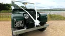Front view of Green Land rover decorated with white Ribbons and a large White Bow at the front