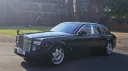 Left side view of Black Rolls-Royce Phantom parked in front of wedding venue