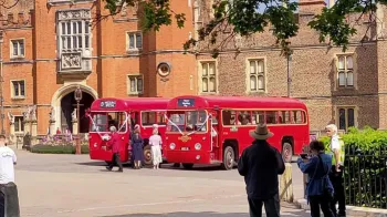 Two identical Red Single Decker buses in front of wedding venue