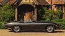 right side view of convertible classic jaguar e-type with roof down parked in front of wedding venue in Surrey