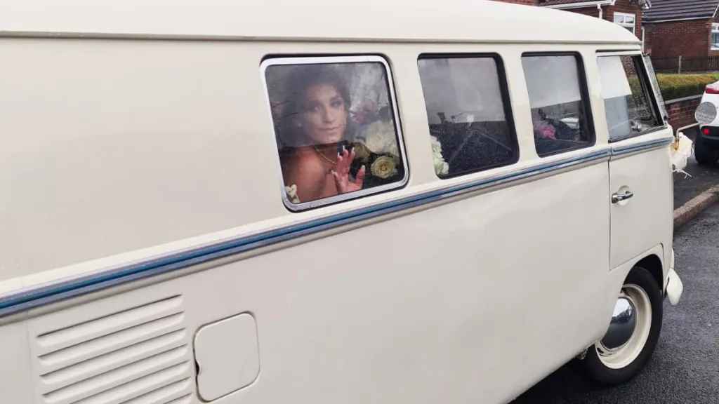 Bride inside campervan looking through one of the window