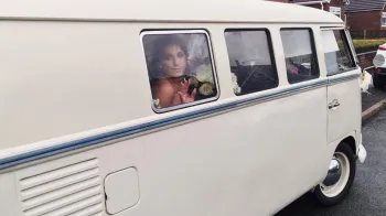 Bride inside campervan looking through one of the window