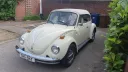 VW beetle in cream with white soft top roof closed
