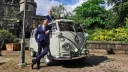 Classic VW campervan parked in street of Southport with Bride and Groom's party posing for photos