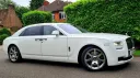 Right side view of a White rolls-Royce Ghost with Chrome wheels