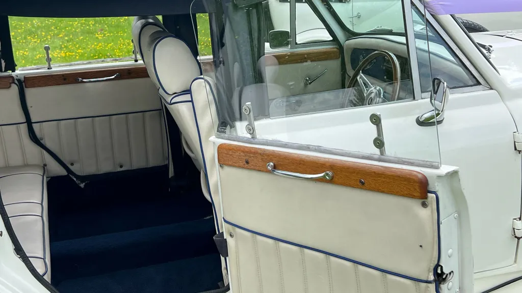 Rear interior photo with royal blue carpet and cream leather seats