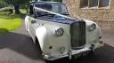 Front view of Austin Princess Limousine in Ivory with Black Bonnet and decorated with Ivory ribbons